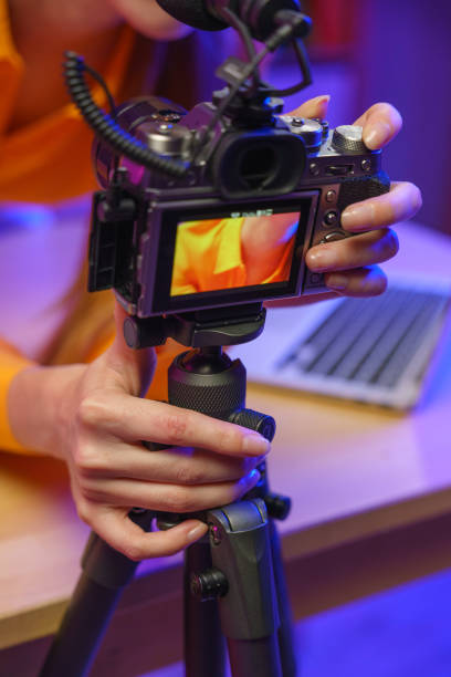 istockphoto-1358969173-612×612-3 A woman puts up settings on her shooting camera in a studio with bright light, we see that in close up